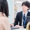 窓口で女性客を対応している男性市役所職員